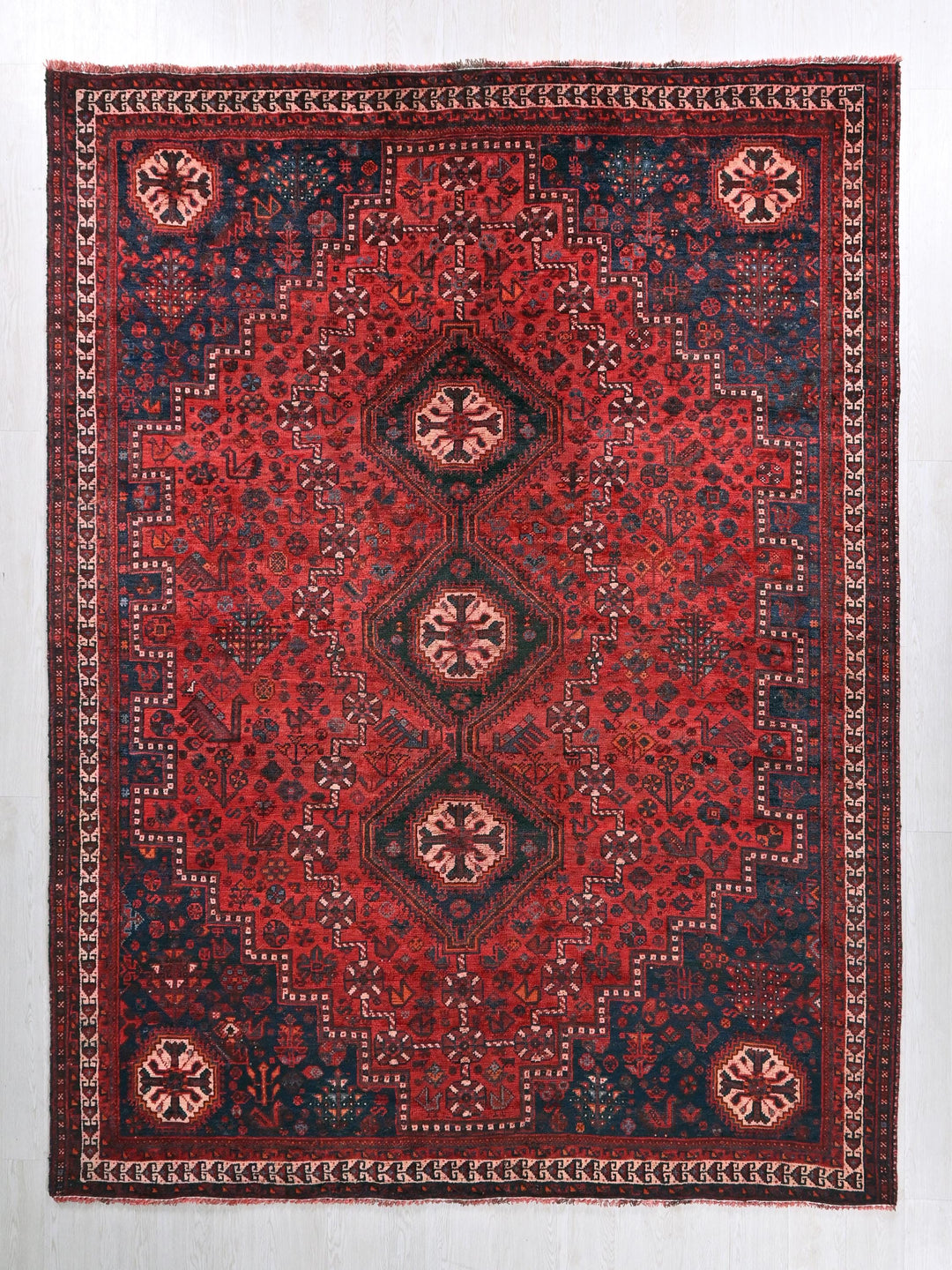 a red, blue and black rug on a white wall