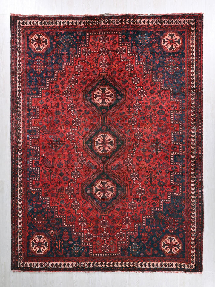 a red, blue and black rug on a white wall