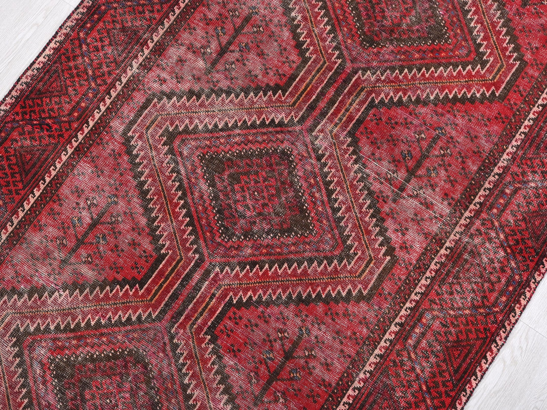a red rug with a diamond pattern on it