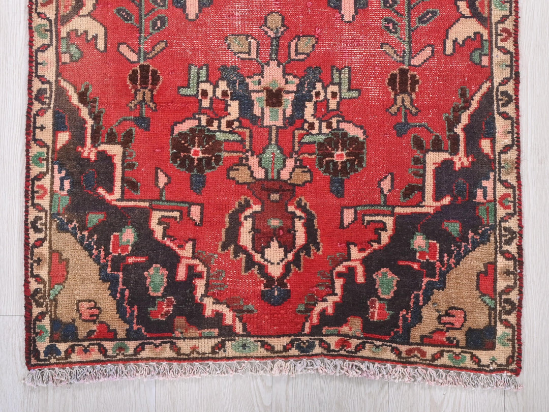 a red rug with a design on the middle of it