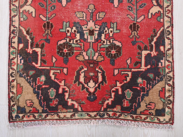 a red rug with a design on the middle of it