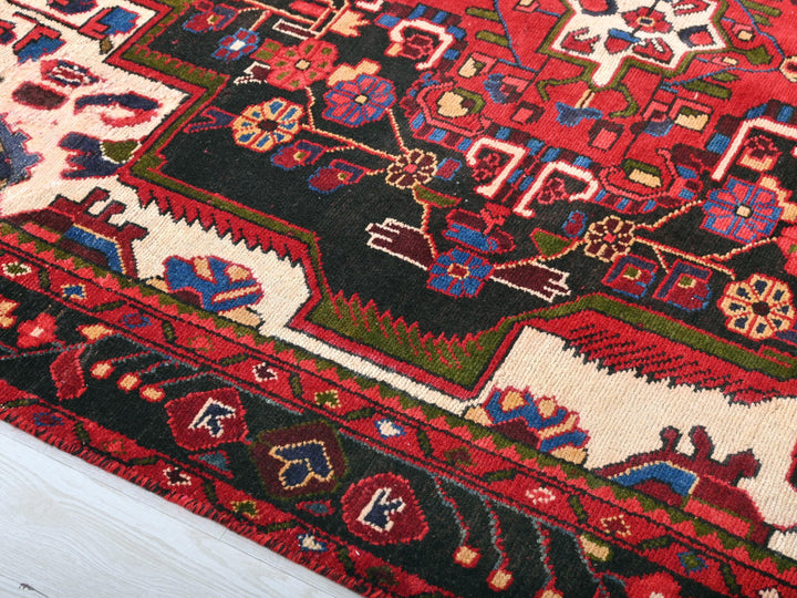a close up of a red rug with many designs
