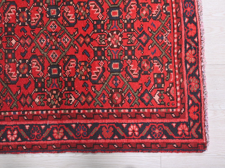 a red rug on a white wooden floor