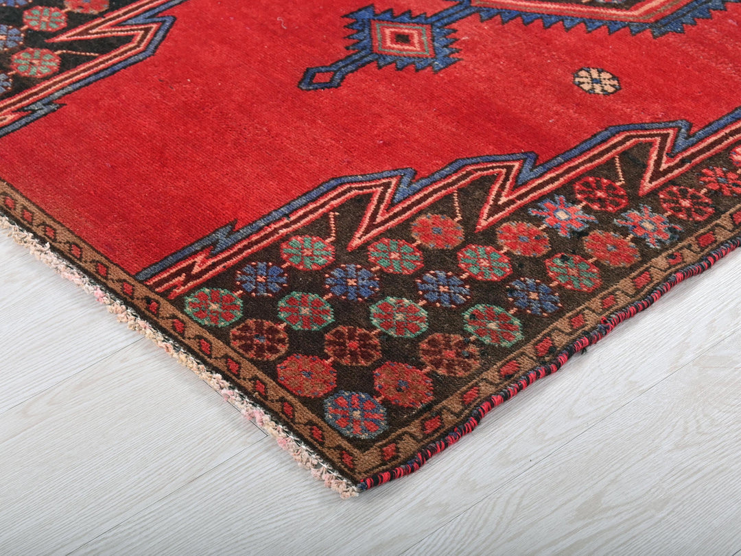 a red rug on a white wooden floor