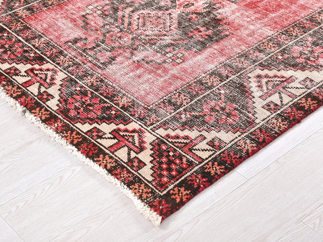a red and black oriental rug on a white floor