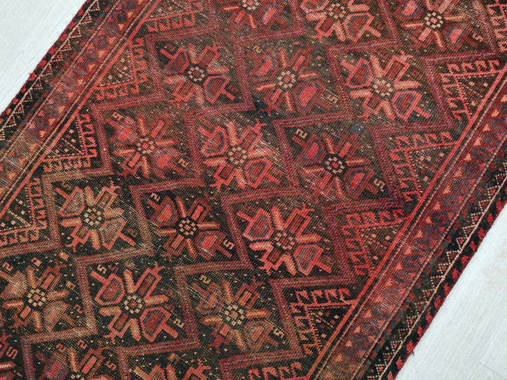 a red and black oriental rug on a white floor