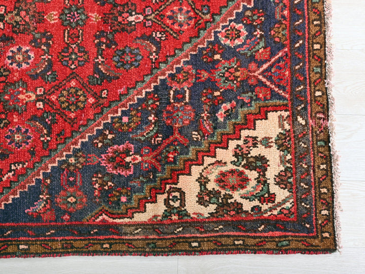 a red and blue rug on a white floor