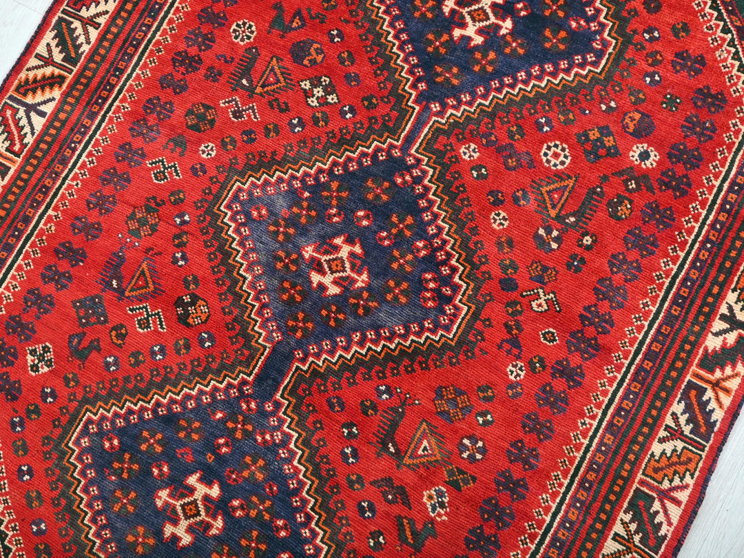a red rug with blue and red designs on it