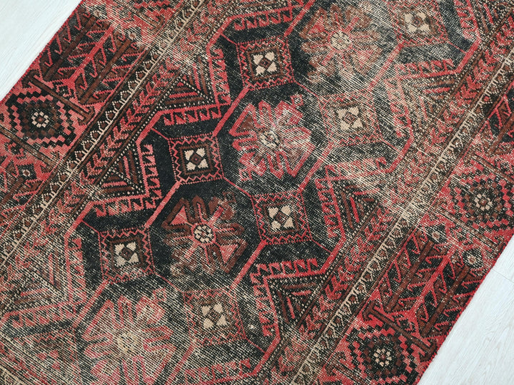 a close up of a red and black oriental rug