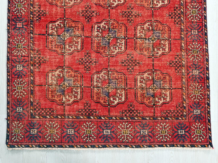 a red rug with a design on the middle of it