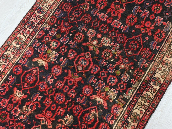 a red and black oriental rug on a white floor