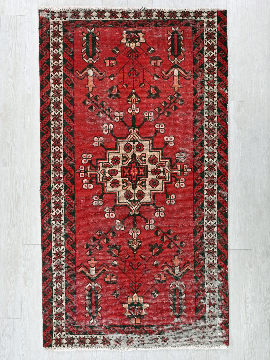 a red rug with a black and white design on it