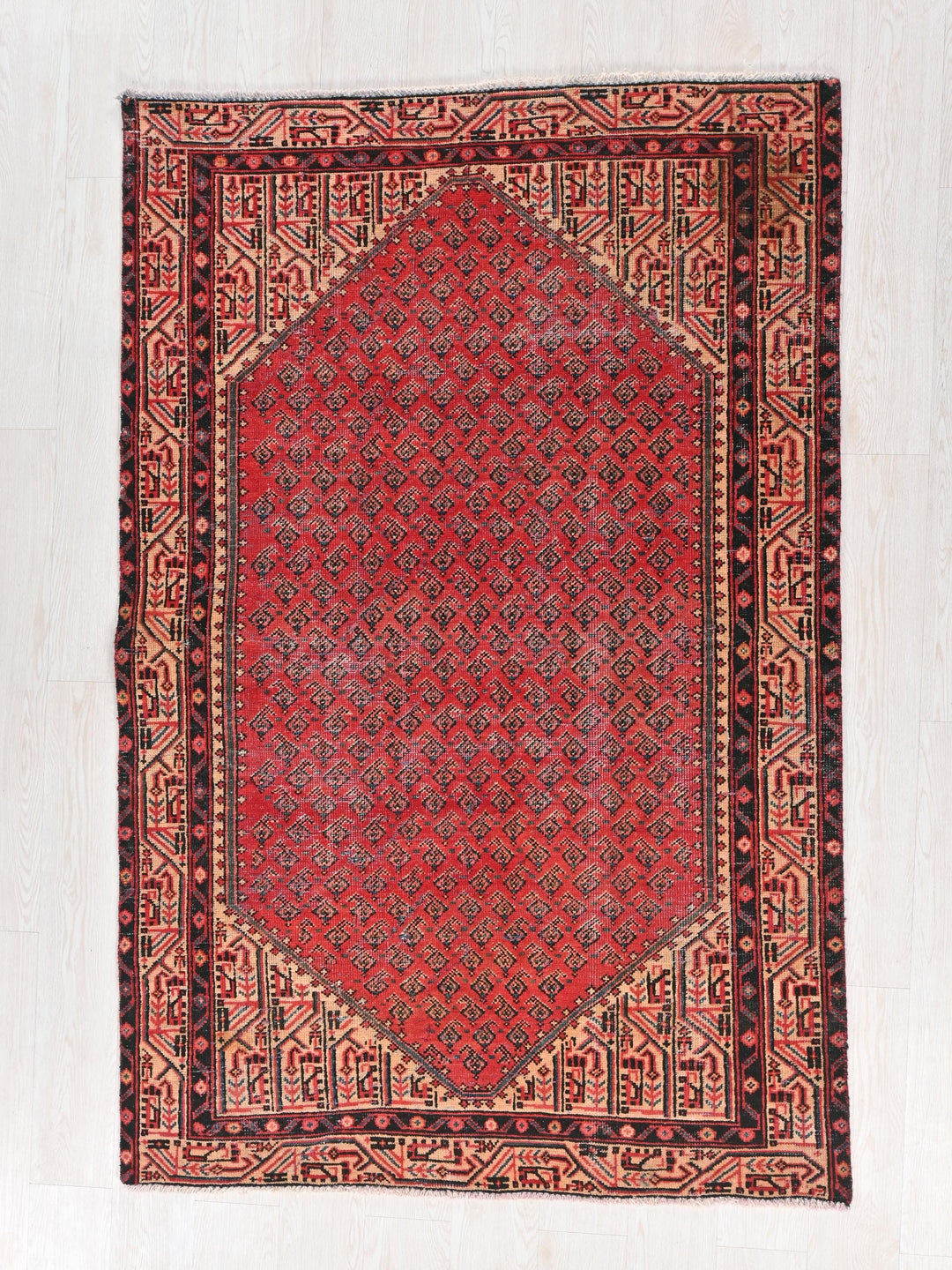 a red and black oriental rug on a white floor