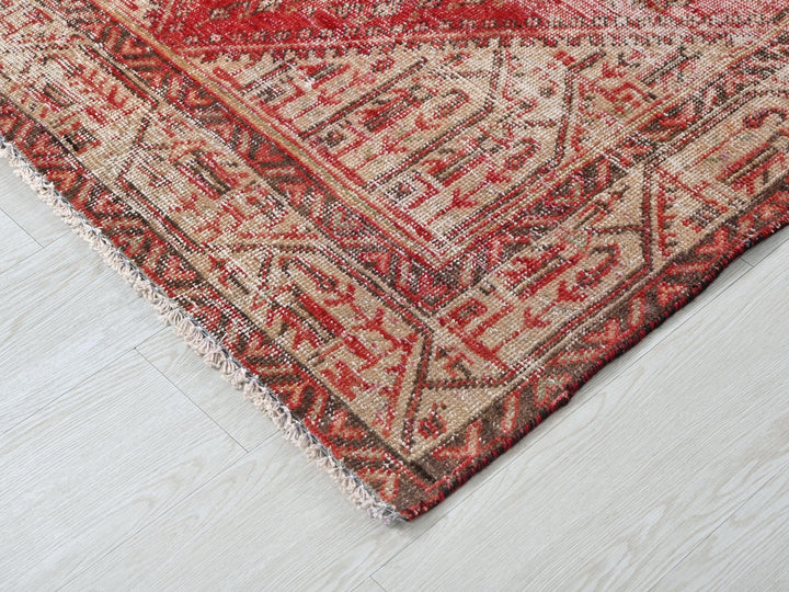 a red and beige oriental rug on a white floor