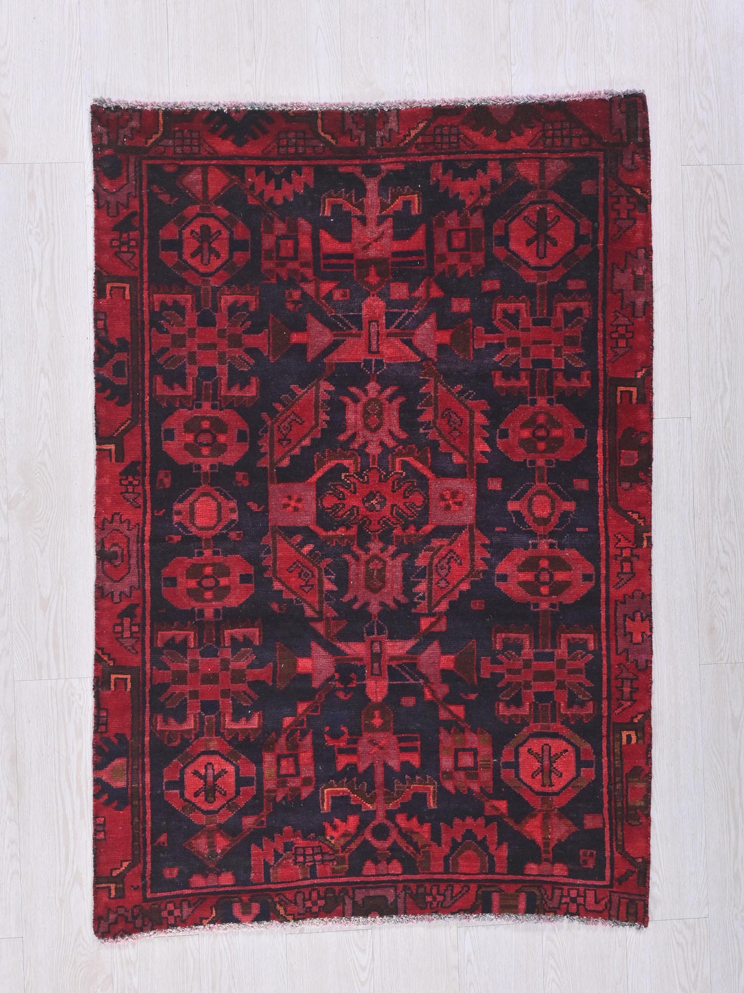 a red and black rug on a white floor