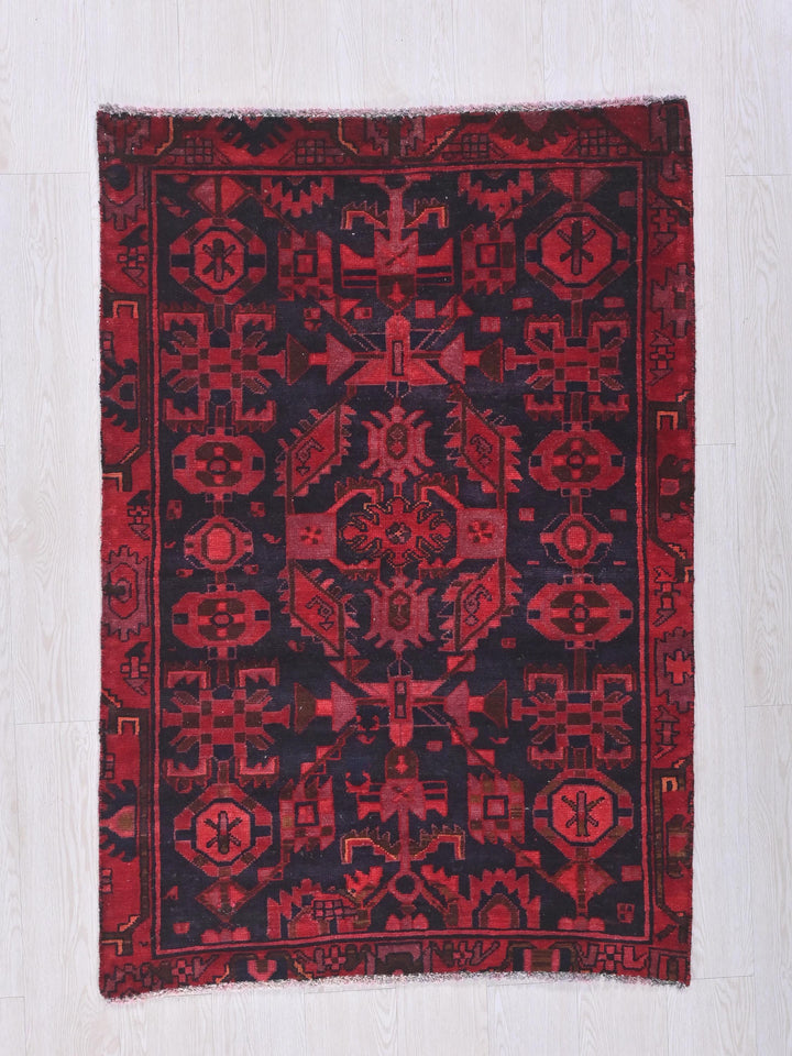 a red and black rug on a white floor