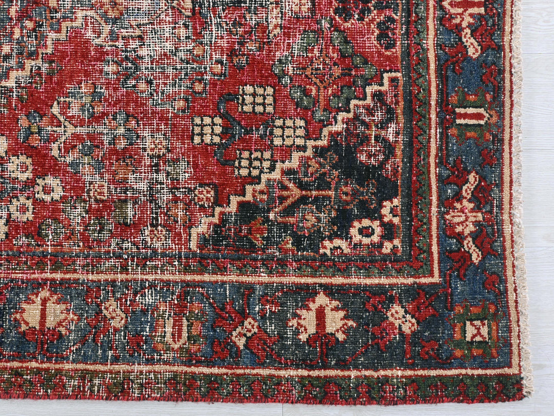 a red and blue oriental rug on a white surface