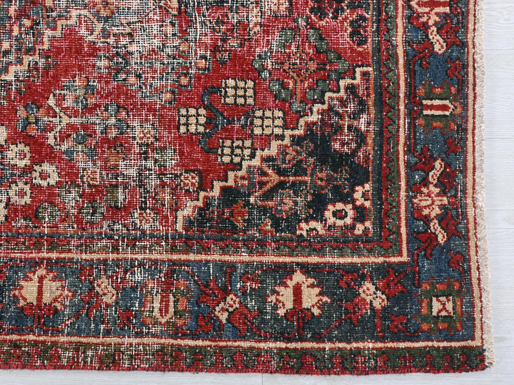 a red and blue oriental rug on a white surface