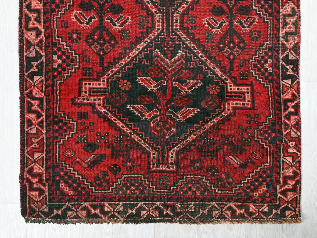 a red and black oriental rug on a white floor