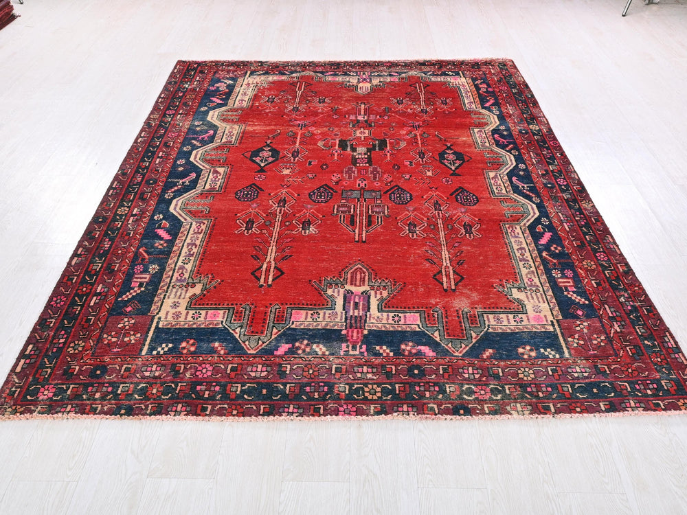 a red rug with a blue border on a white floor