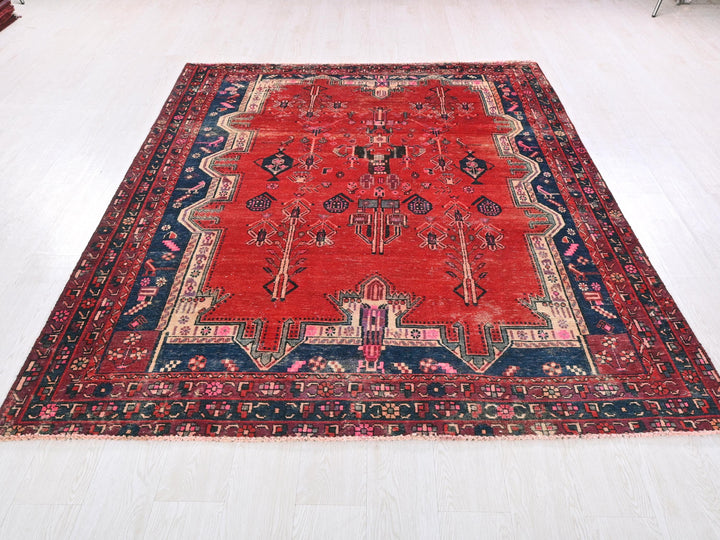 a red rug with a blue border on a white floor