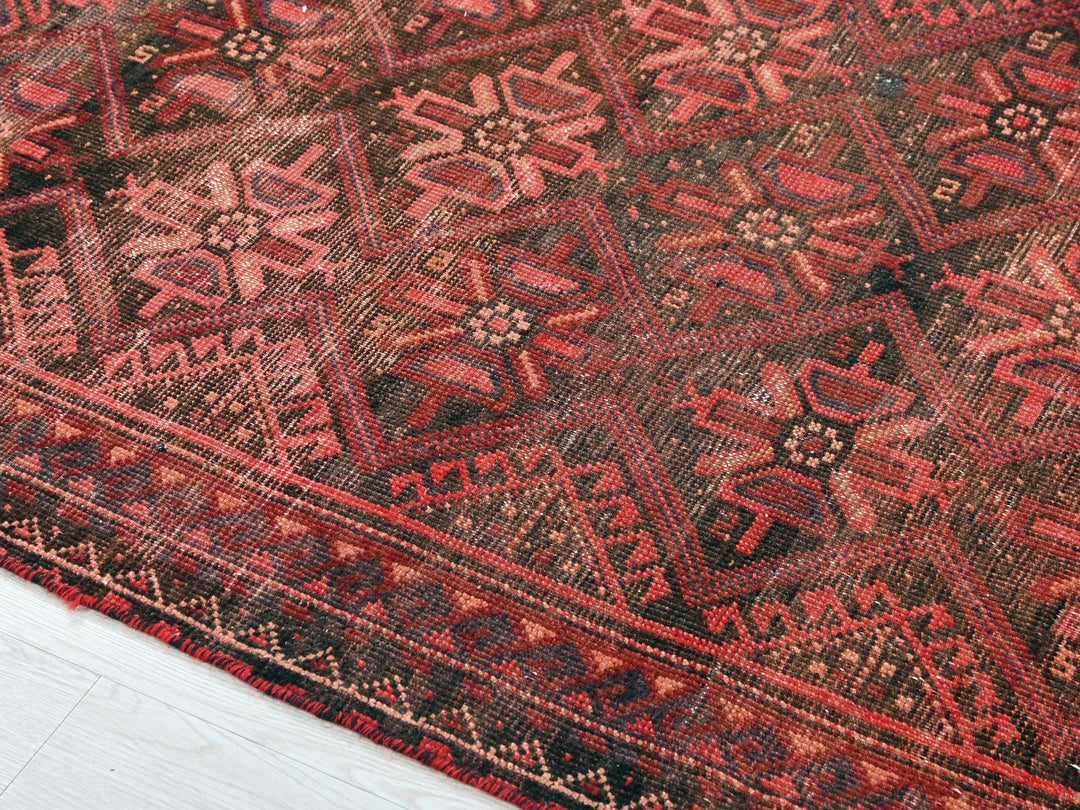 a red and black oriental rug on a white floor