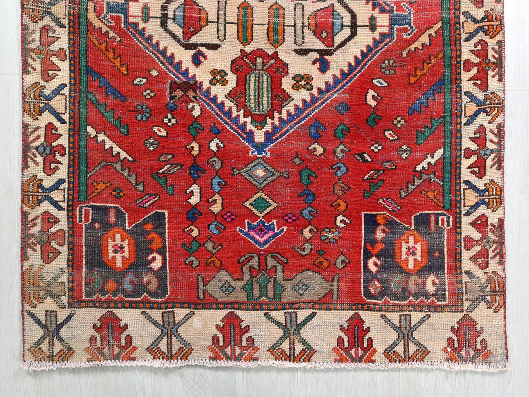 a red rug with a design on the middle of it