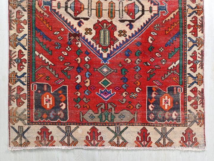a red rug with a design on the middle of it