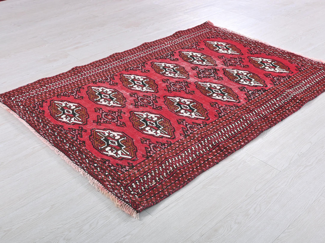 a red and black rug sitting on top of a white floor