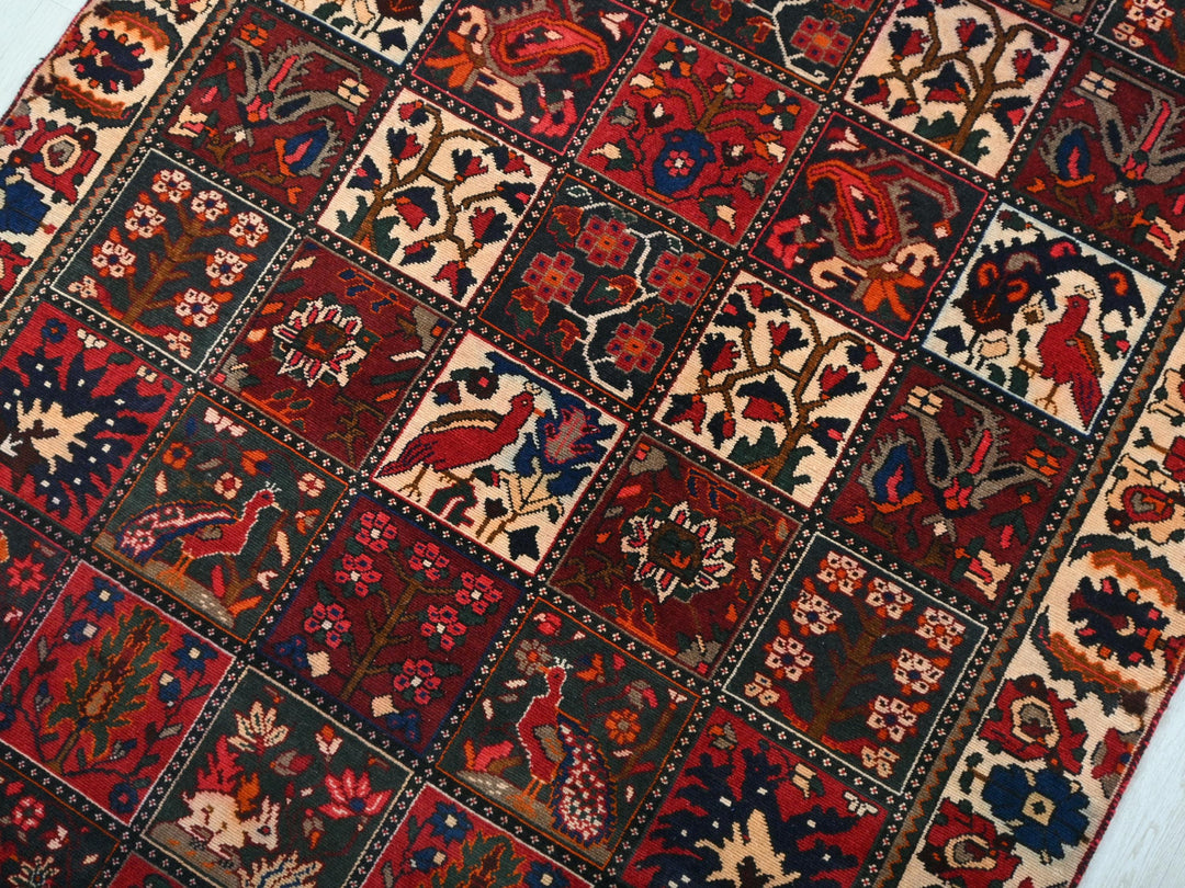 a red and blue rug with a pattern of birds and flowers