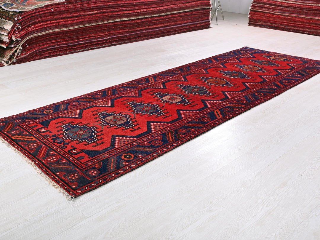 a pile of red rugs sitting on top of a white floor