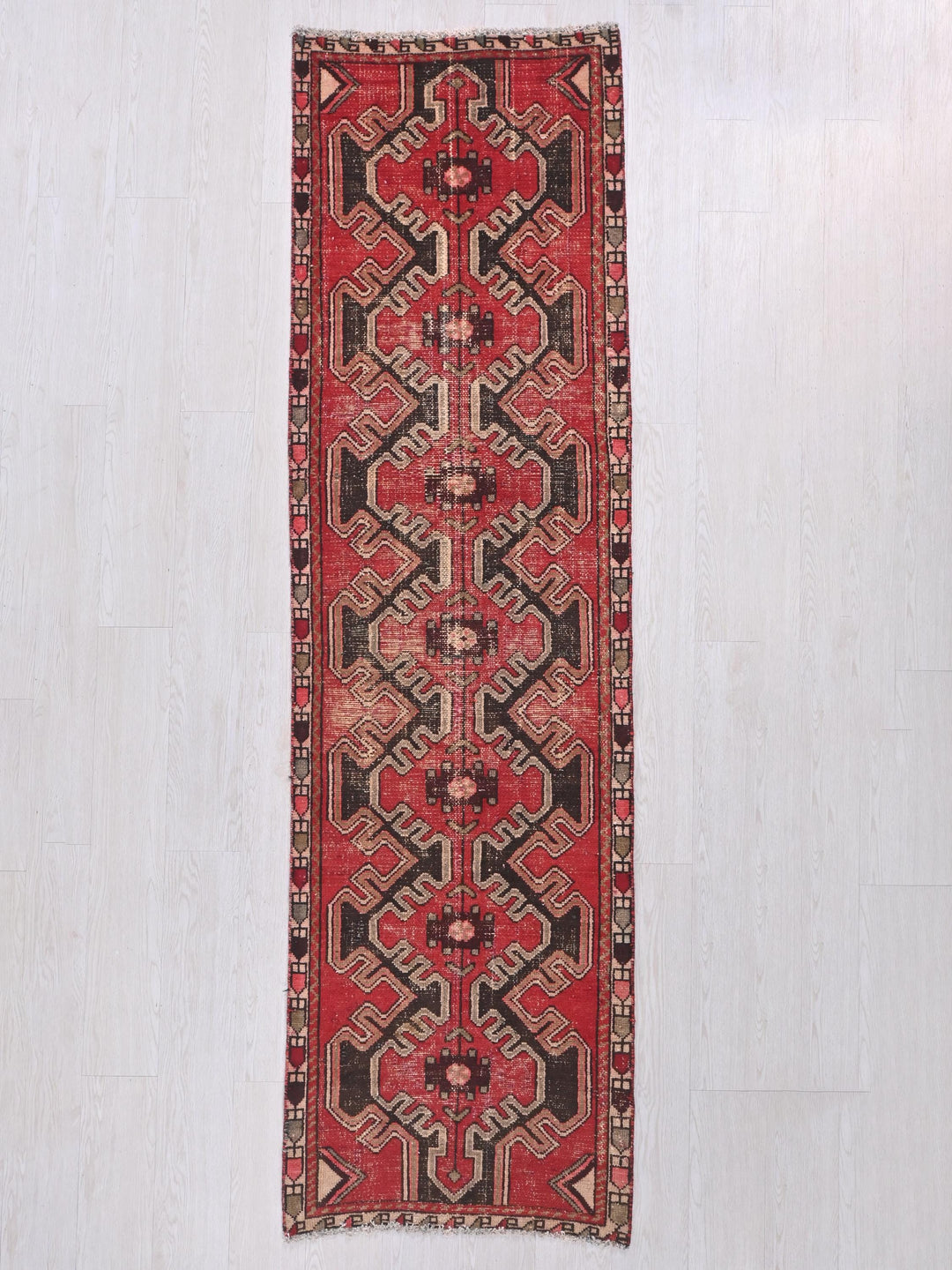 a red rug hanging on a white wall
