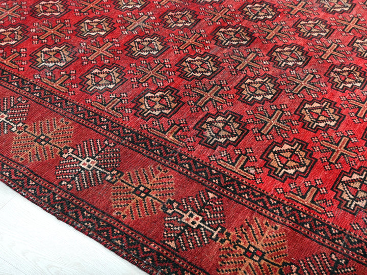 a red rug with a pattern on it
