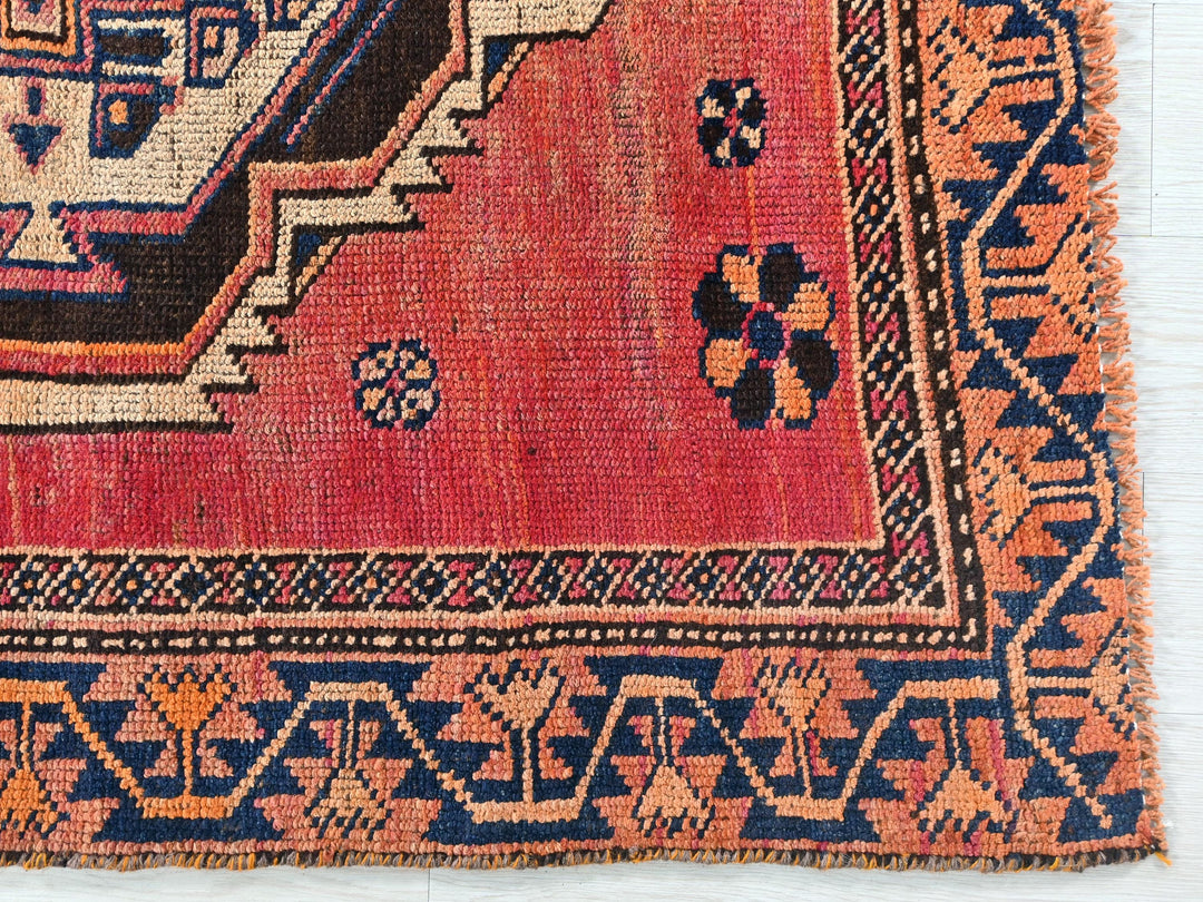 a red rug with a blue and orange design on it