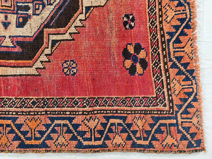 a red rug with a blue and orange design on it
