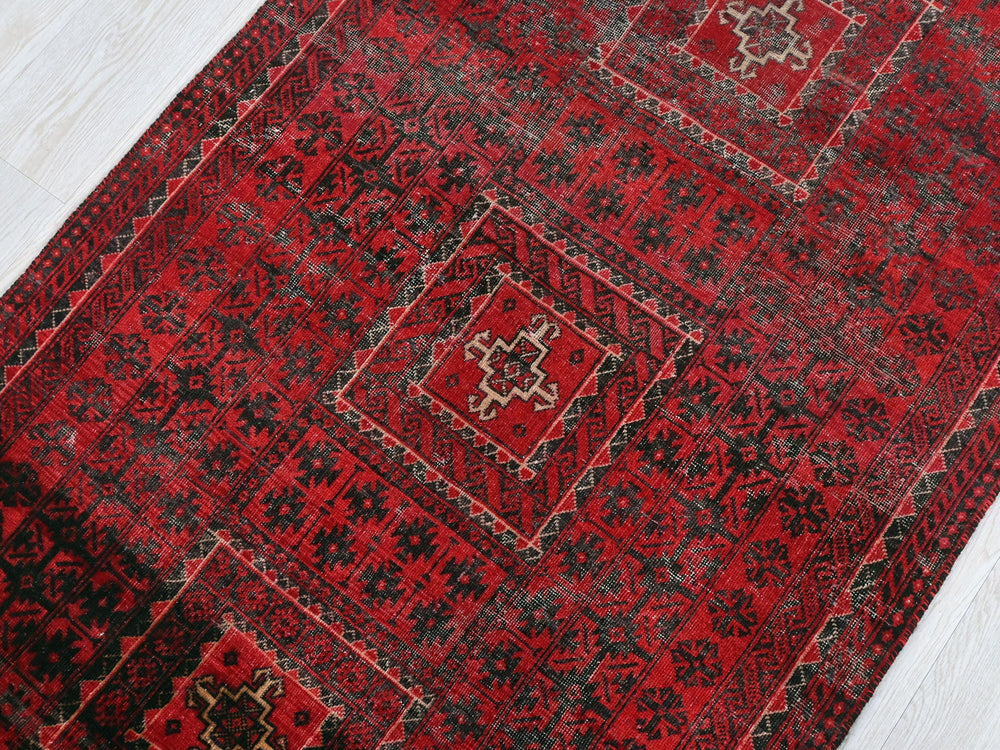 a red rug on a white wooden floor