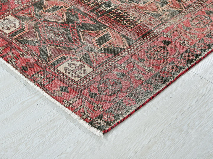 a red and black oriental rug on a white floor