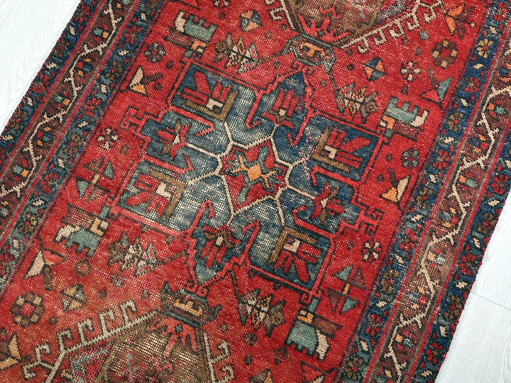 a red oriental rug on a white wooden floor