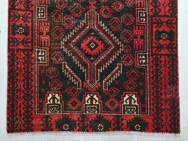 a red and black rug on a white background
