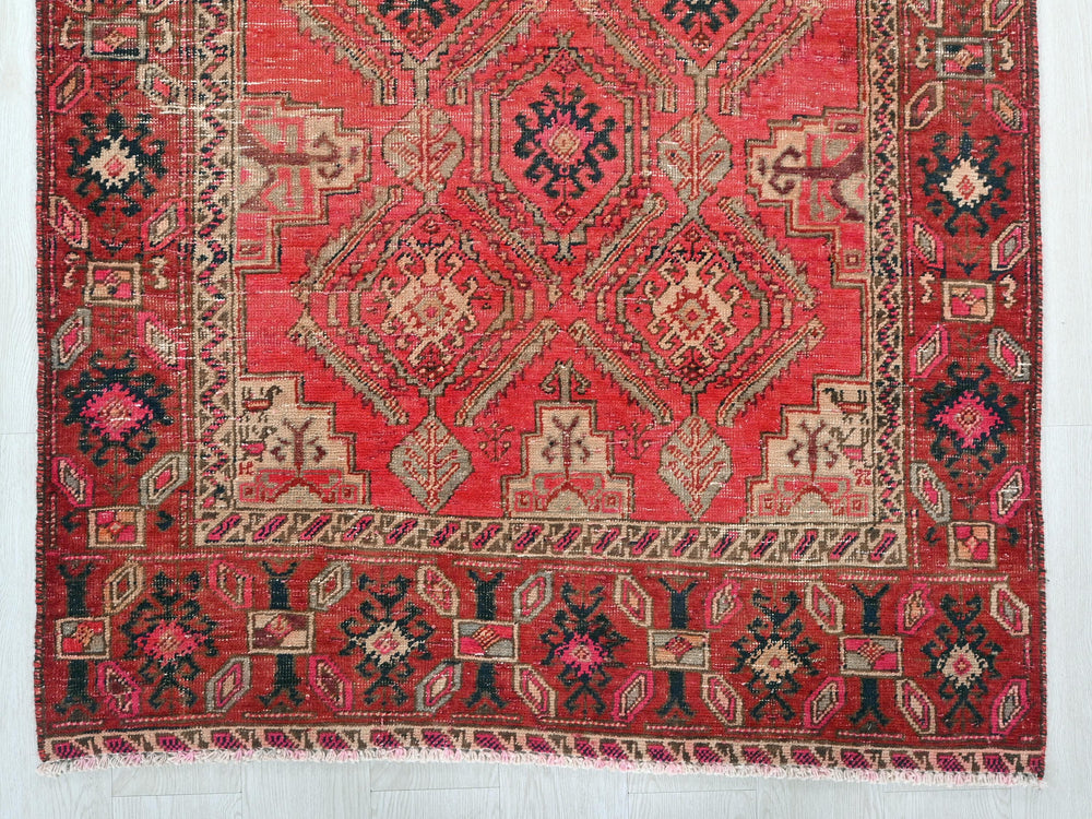 a red rug with a design on the middle of it