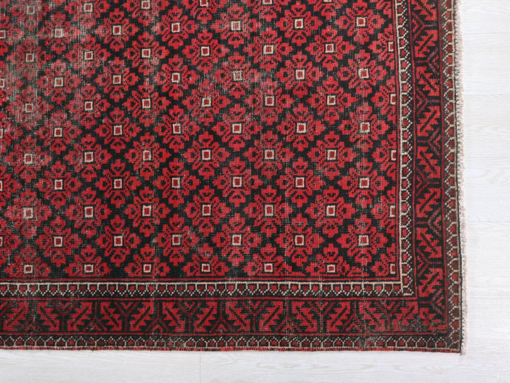 a red and black rug on a white floor