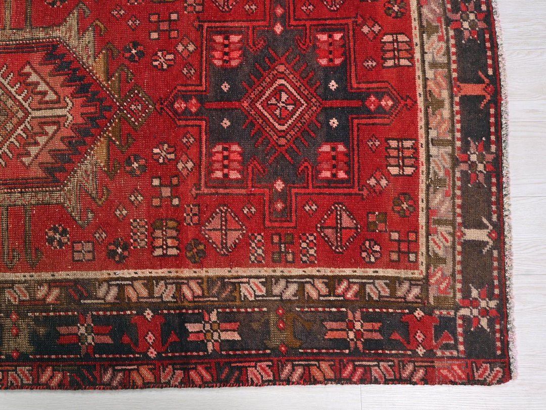 a red oriental rug on a white wooden floor