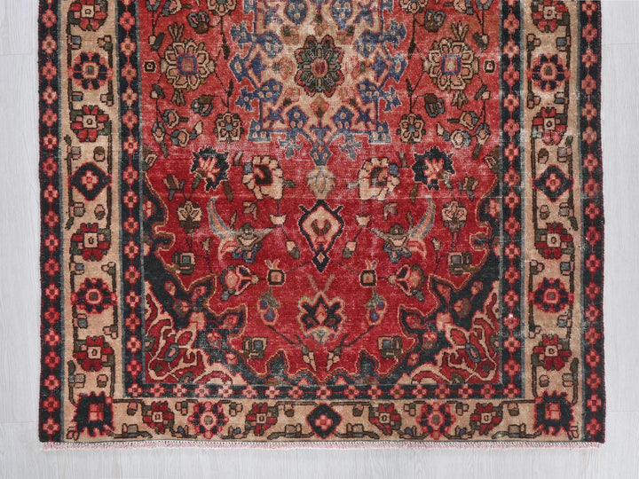 a red rug with a black border on a white wall