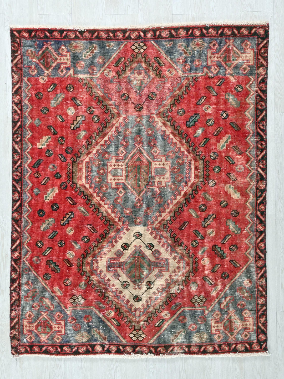 a red and blue rug on a white wall