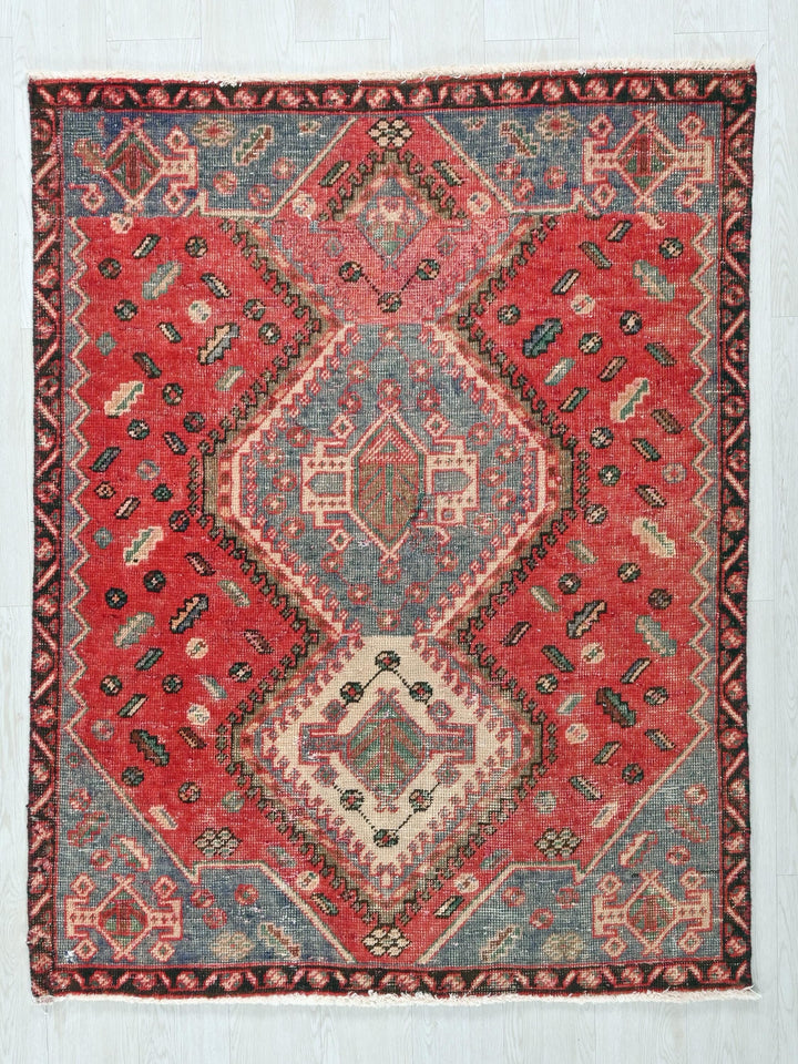 a red and blue rug on a white wall