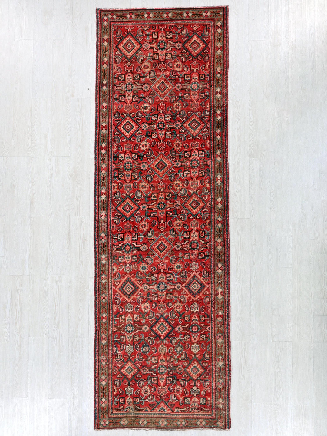 a red rug hanging up against a white wall