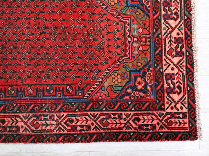 a red rug with a design on it