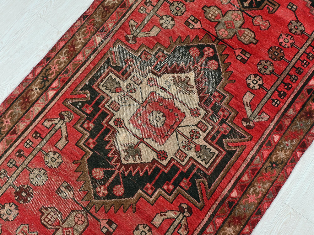 a red oriental rug on a white wooden floor
