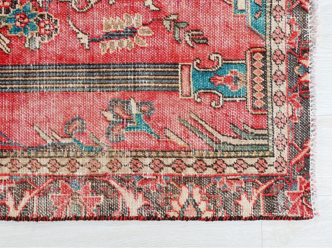 a red rug with a floral design on it