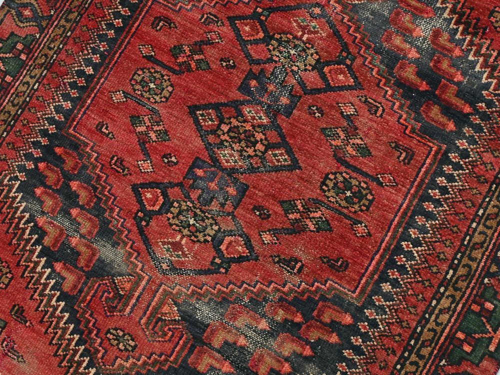 a red oriental rug with a black border